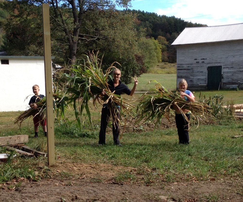 Conrad, Christine, and Ava Depew of Clifford have fun gathering cornstalks to sell as a fundraiser for the Clifford Children’s Garden.